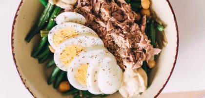 Delicious protein-packed bowl featuring tuna, boiled eggs, green beans, and hummus.