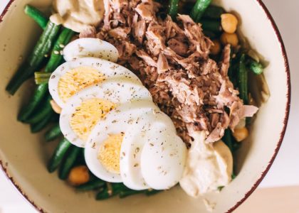 Delicious protein-packed bowl featuring tuna, boiled eggs, green beans, and hummus.